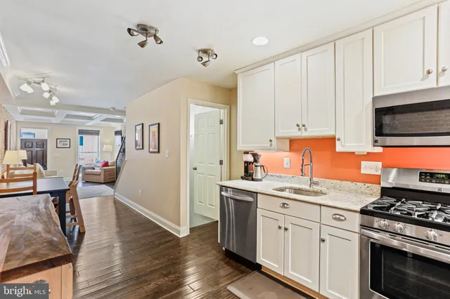 a kitchen with stainless steel appliances granite countertop a stove and white cabinets