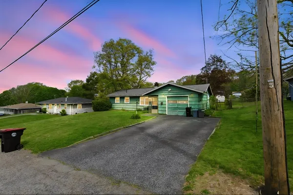 a front view of a house with a yard and garage