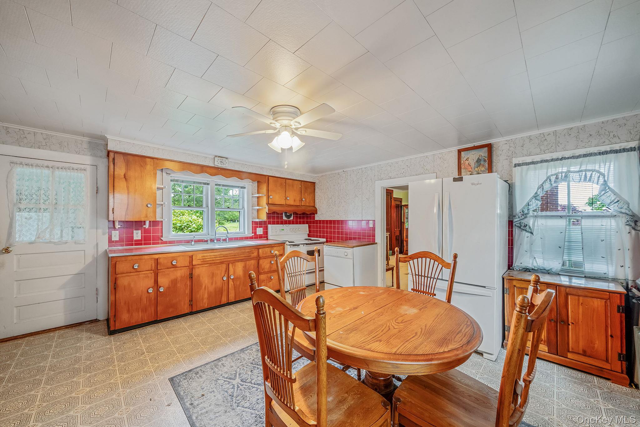 1055 Oregon Road Mattituck, NY 11952 - Photo 7 of 33 Kitchen featuring wood cabinetry, and a window above the sink overlooking the scenic yard,