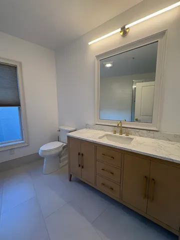 a bathroom with a double vanity sink toilet and a mirror