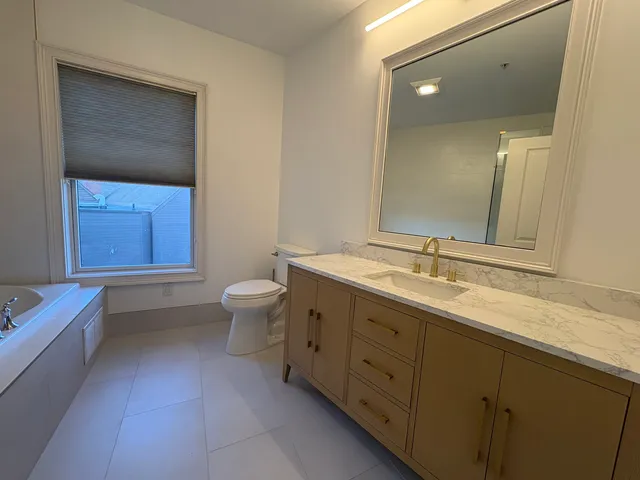 a bathroom with a double vanity sink a toilet and a mirror