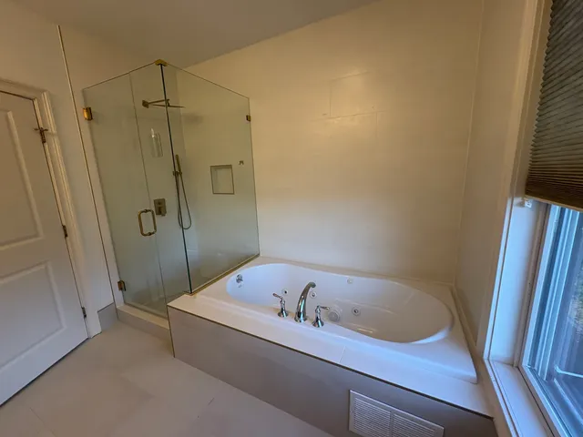 a bathroom with a tub and a shower