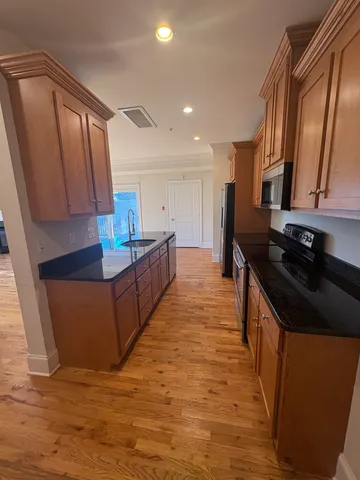 a kitchen with stainless steel appliances granite countertop a stove a sink and a refrigerator