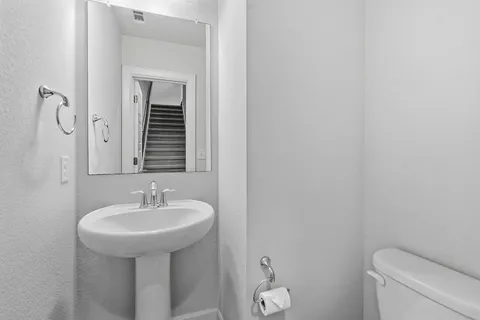a bathroom with a sink a toilet and mirror