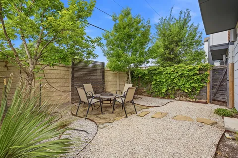 a view of backyard with a table and chairs and potted plants