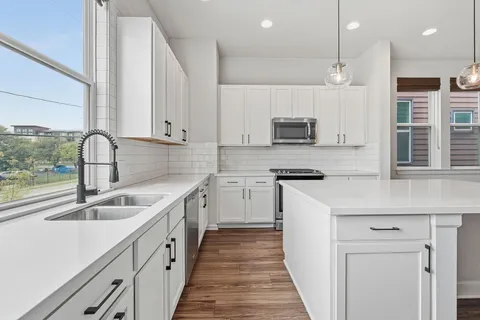 a kitchen that has a sink and a stove top oven