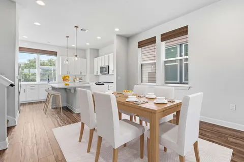 a dining room with furniture a window and wooden floor