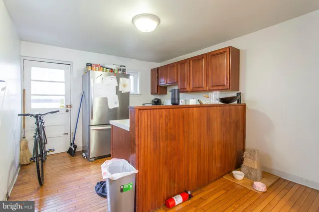 a kitchen with stainless steel appliances granite countertop a refrigerator a sink dishwasher and wooden cabinets with wooden floor