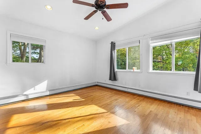 a view of an empty room with a window and a ceiling fan