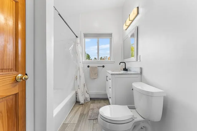 a white toilet sitting next to a bathroom sink and a window