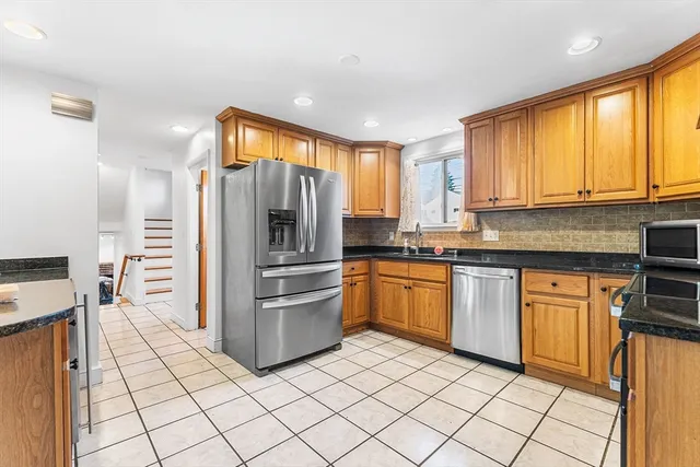 a kitchen with stainless steel appliances granite countertop a refrigerator and a stove top oven