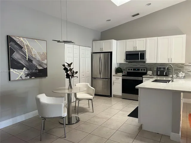 a kitchen with stainless steel appliances a refrigerator sink and stove