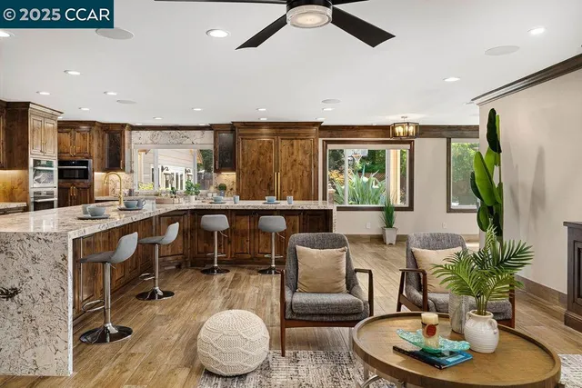 a large kitchen with stainless steel appliances granite countertop a large counter top and a wooden floors