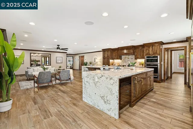 a kitchen with stainless steel appliances granite countertop a sink a stove and a wooden floors