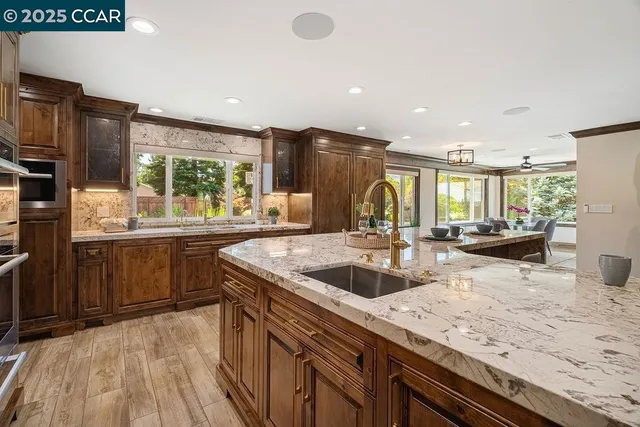 a dining room with wooden floor a chandelier a glass table and chairs