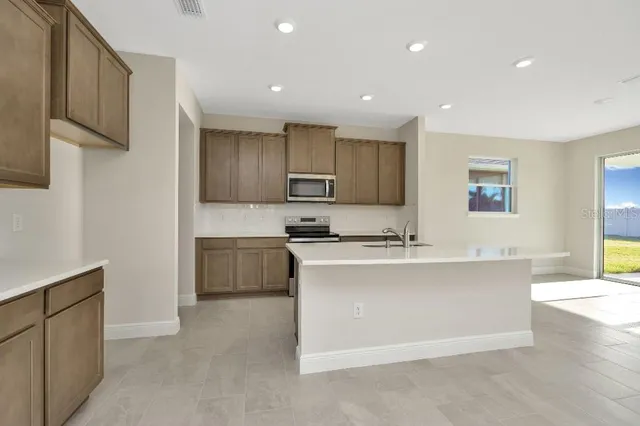 a kitchen with stainless steel appliances a sink stove and cabinets