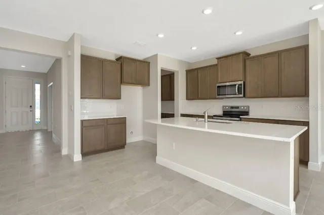 a kitchen with stainless steel appliances a refrigerator sink microwave and cabinets