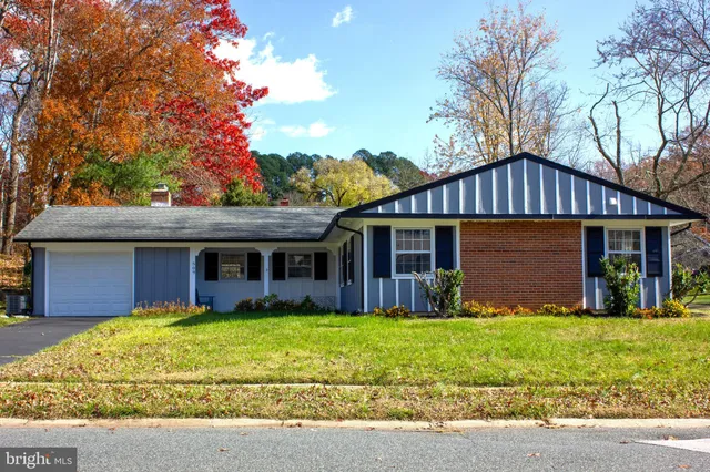 a view of a house with a yard and large tree