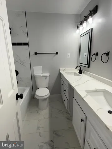 a spacious bathroom with a granite countertop sink toilet and shower