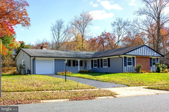 a view of a house with a yard and large tree