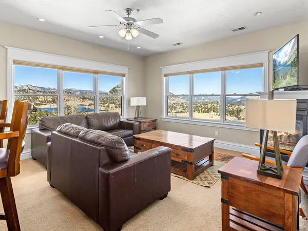 a living room with couches a flat tv screen and a coffee table