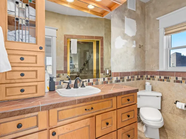 a bathroom with a toilet a sink and a mirror