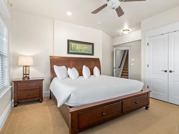 a spacious bedroom with a bed and a chandelier