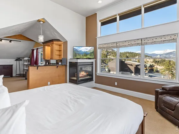 a bedroom with a large bed and a large window with the outer view
