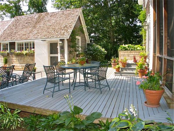 709 Old County Road West Tisbury, MA 02568 - Photo 2 of 22 a view of a patio with table and chairs potted plants with wooden floor and fence