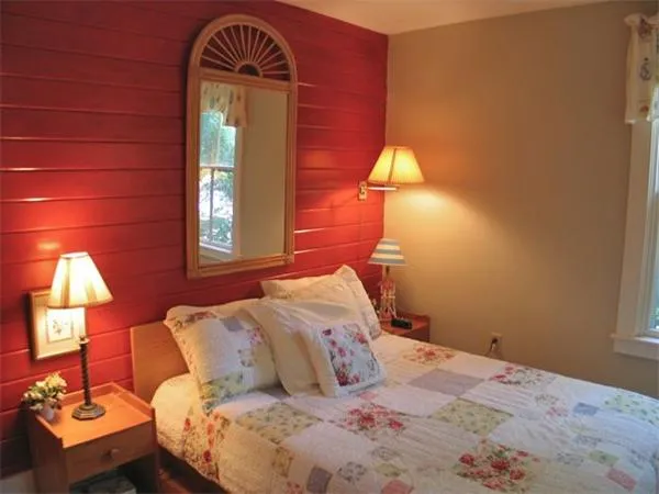 a bedroom with a bed and a lamp on dresser