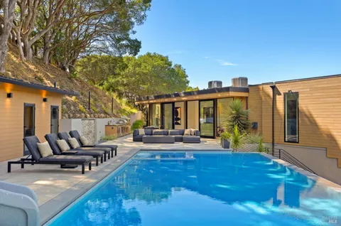 a view of a house with swimming pool and sitting area