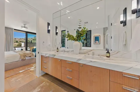 a bathroom with a granite countertop sink a toilet a mirror and shower
