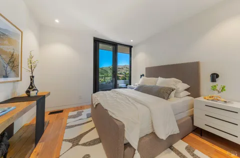 a view of a patio with couches and table under an umbrella next to a yard