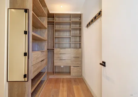 a view of a backyard with couches chair and floor to ceiling window and potted plants