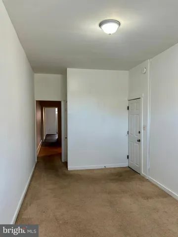 an empty room with closet and wooden door