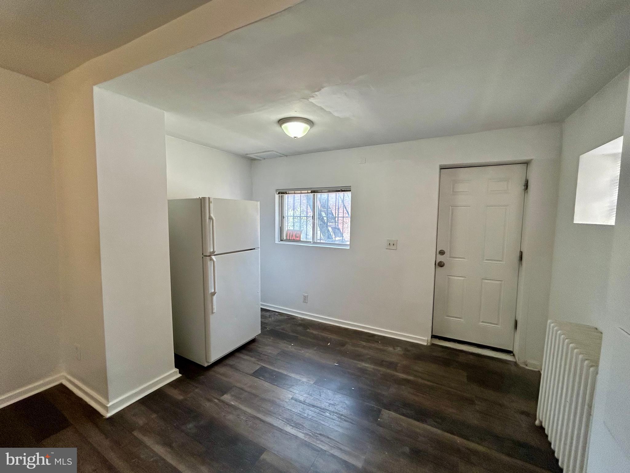 2504 North Calvert Street, Unit 1 Baltimore, MD 21218 - Photo 8 of 13 an empty room with wooden floor and a window