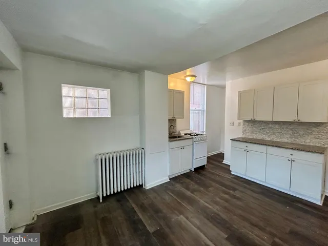 a kitchen with granite countertop white cabinets and white appliances