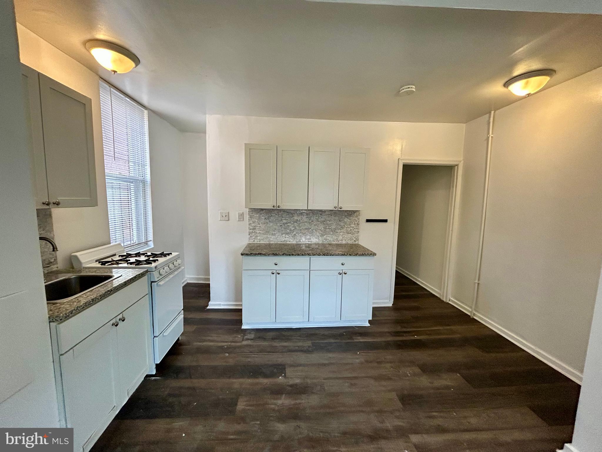 2504 North Calvert Street, Unit 1 Baltimore, MD 21218 - Photo 10 of 13 a kitchen with granite countertop a stove and a sink