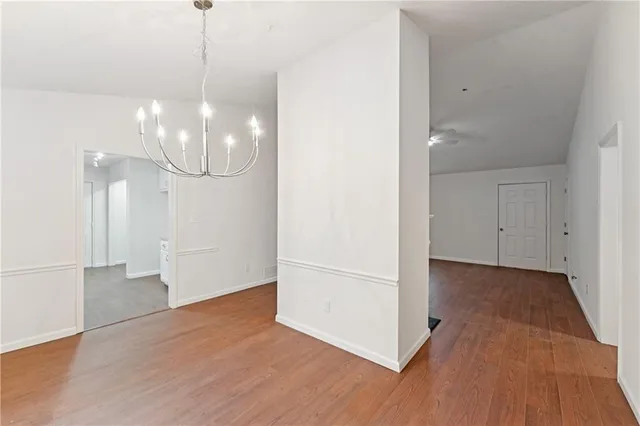a view of a room with wooden floor chandeliers and kitchen