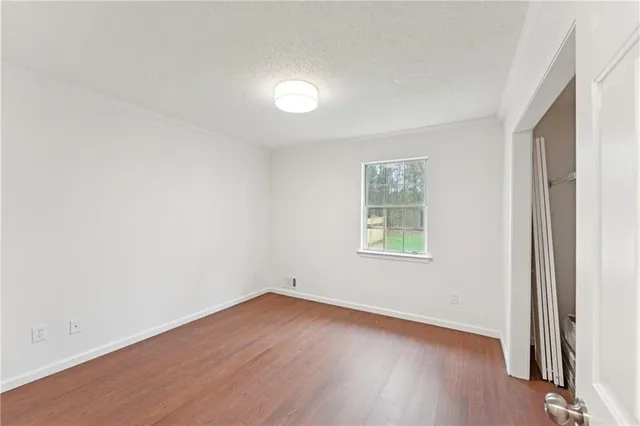 a view of empty room with wooden floor