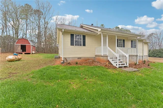 a view of a house with a yard and sitting area