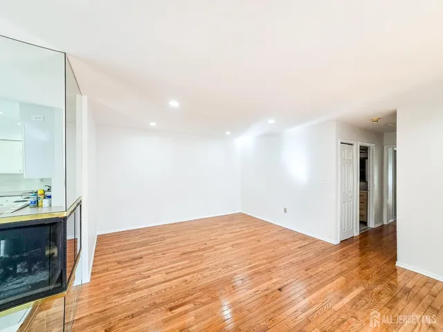 a view of empty room with wooden floor and fireplace