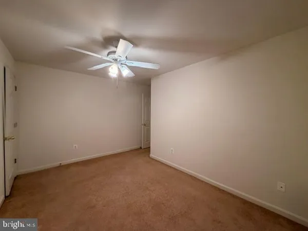 an empty room with a ceiling fan and a fan