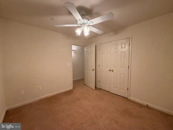 an empty room with chandelier fan