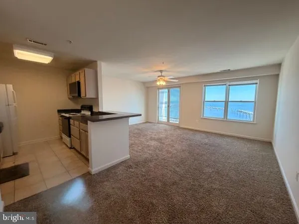 an empty room with a lamp and a chandelier fan