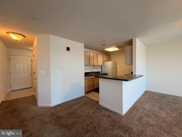 a kitchen with granite countertop a refrigerator and a stove top oven