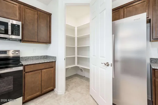 a kitchen with stainless steel appliances granite countertop a refrigerator and a stove top oven
