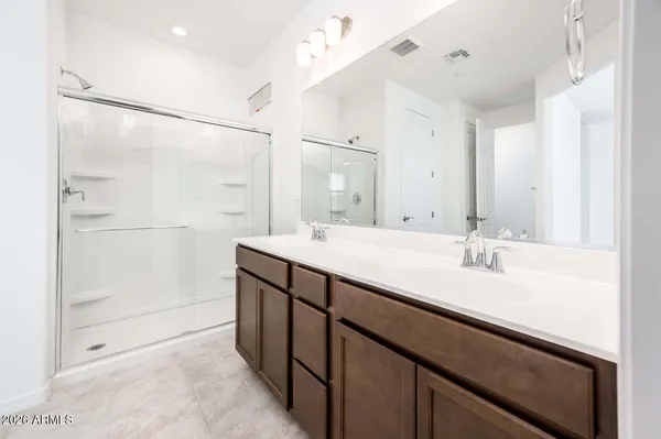 a bathroom with a double vanity sink a mirror and shower