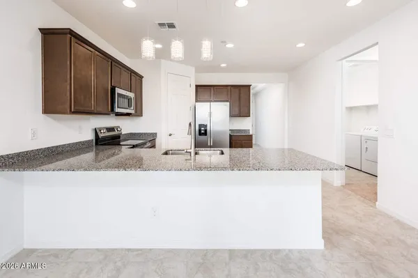a large kitchen with stainless steel appliances kitchen island granite countertop a large counter top and sink