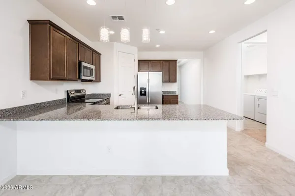 a large kitchen with stainless steel appliances kitchen island granite countertop a large counter top and sink